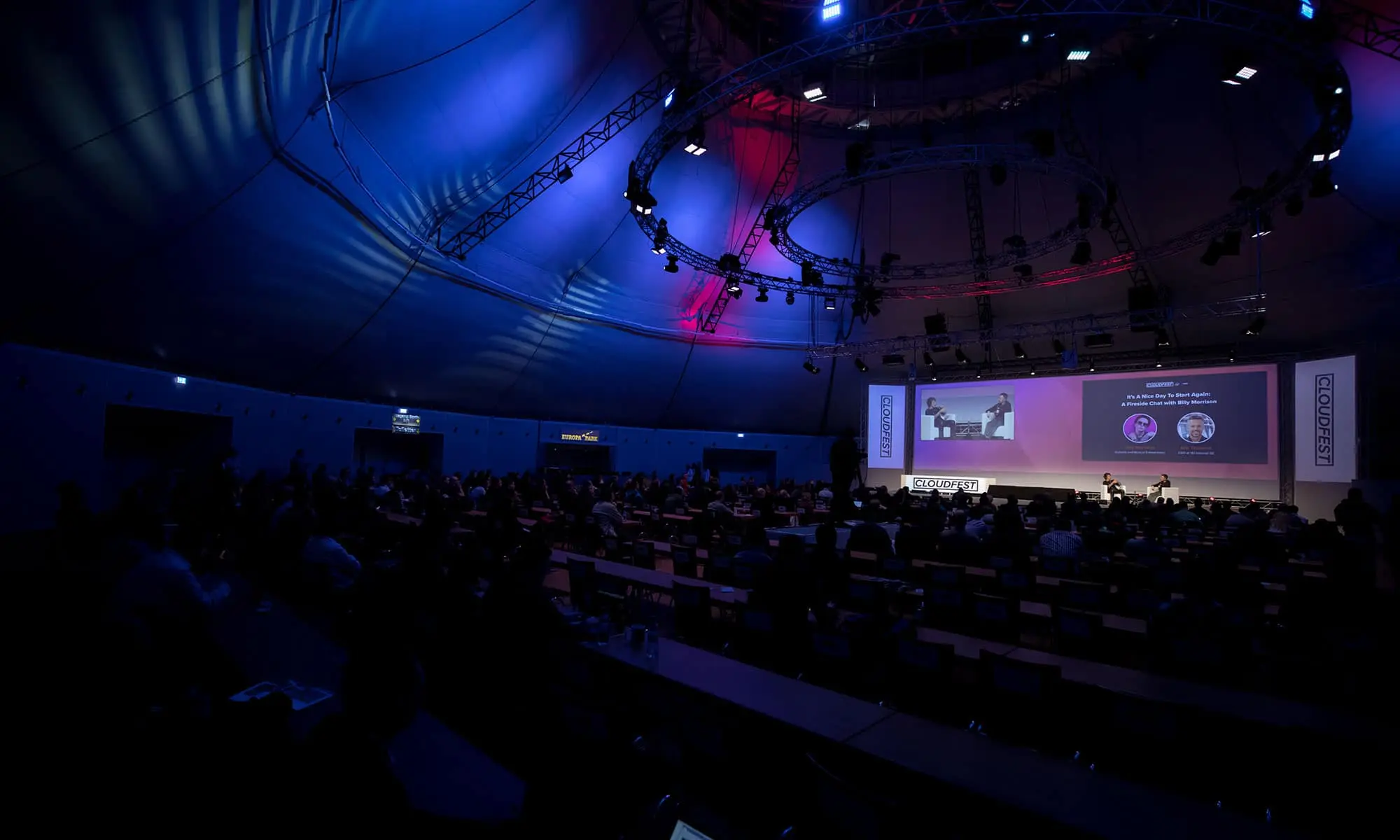 Cloudfest Eventsaal voller Besucher, die einer Podiumsdiskussion folgen